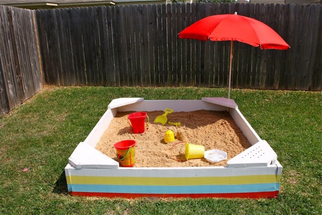 Простая квадратная песочница с угловыми сиденьями и солнцезащитным зонтом