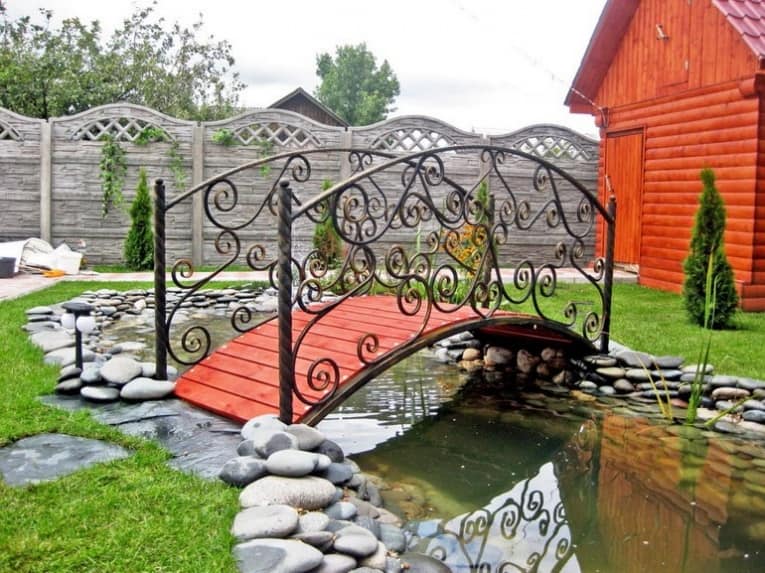 Красивый красный садовый мостик из маталла и дерева
