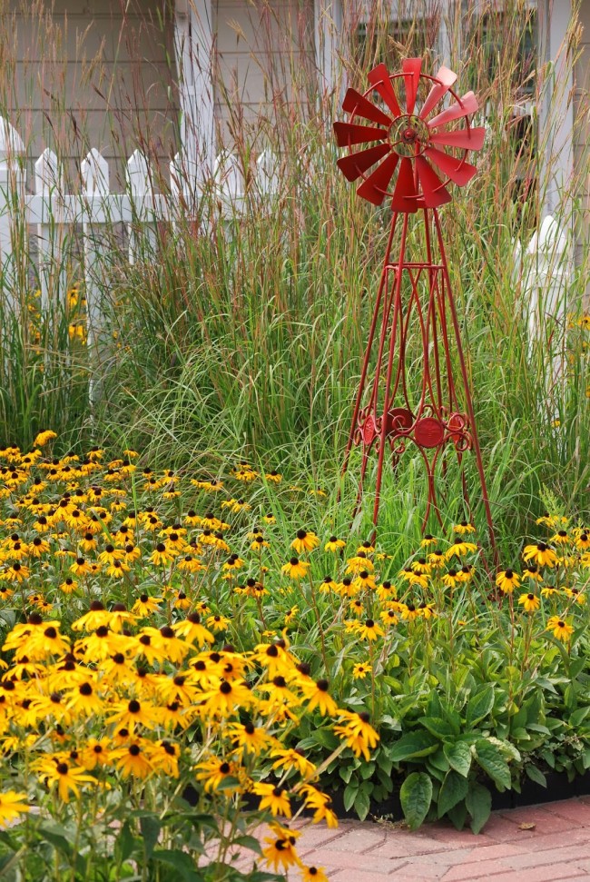 Декоративная мельница для сада, выполненная в металле, лучше смотрится, если ее выкрасить в яркий цвет, например, красный